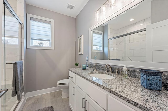 bathroom featuring visible vents, a healthy amount of sunlight, vanity, and a shower stall