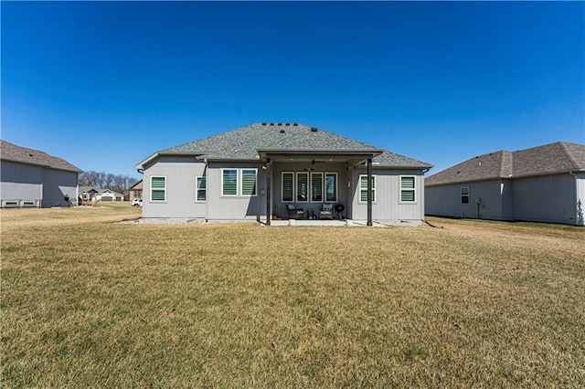 back of property with a yard and a patio area