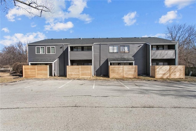 view of front of house featuring fence and uncovered parking