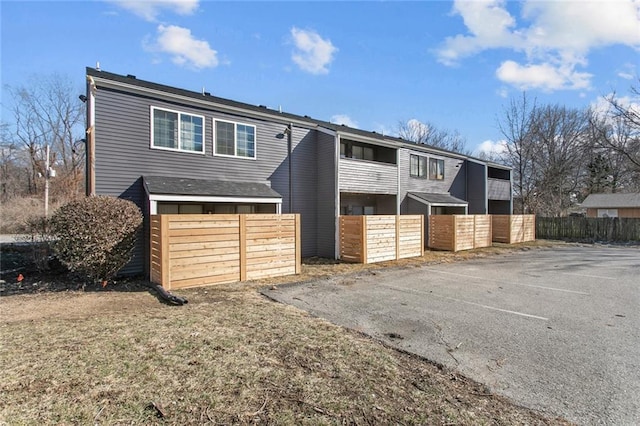 view of front of property featuring uncovered parking and fence