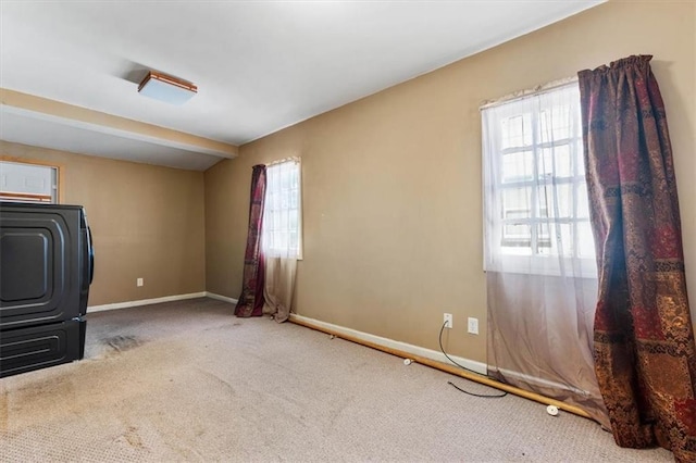 spare room featuring washer / clothes dryer, baseboards, and carpet floors