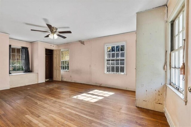 unfurnished room with hardwood / wood-style floors, baseboards, and ceiling fan