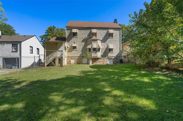 back of house featuring a yard, fence, and a chimney