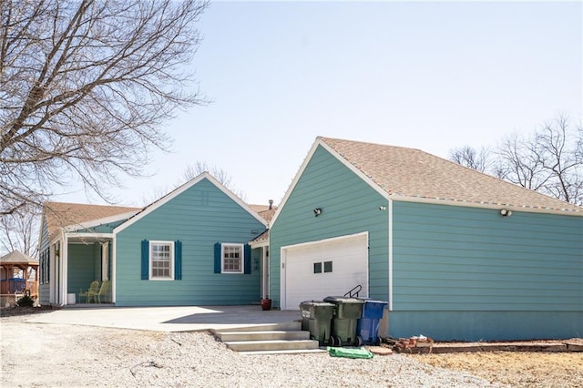 back of house featuring a shingled roof