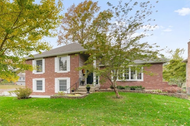 view of front facade featuring brick siding and a front yard