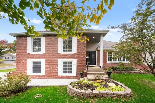 view of front of property featuring brick siding and a front yard