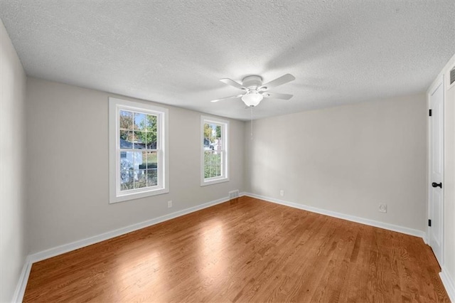 empty room with visible vents, baseboards, and wood finished floors