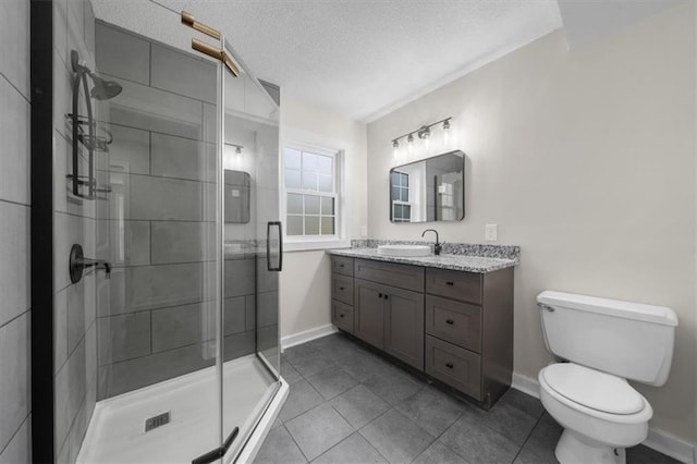 bathroom featuring a textured ceiling, a stall shower, vanity, and toilet