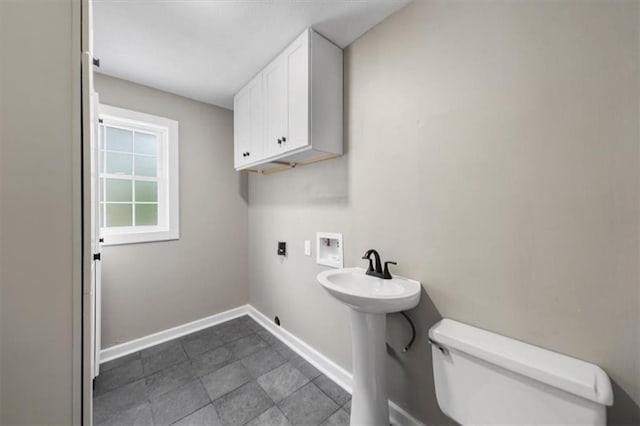 half bathroom with toilet and baseboards