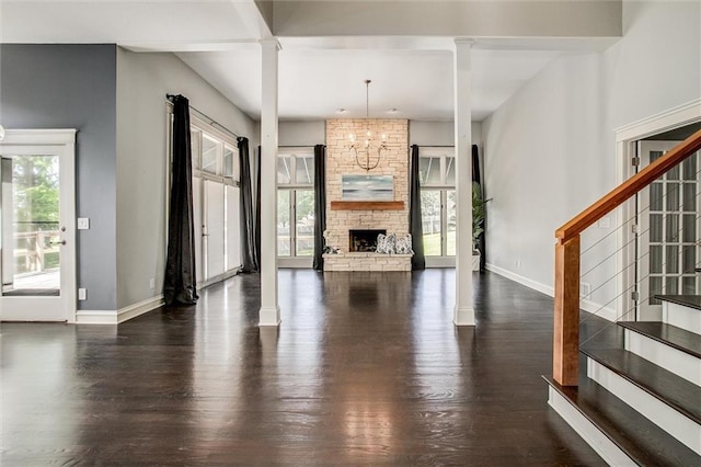 4837 W 121st St, Overland Park, KS 66209 - unfurnished living room featuring ornate columns, wood finished floors, and stairway