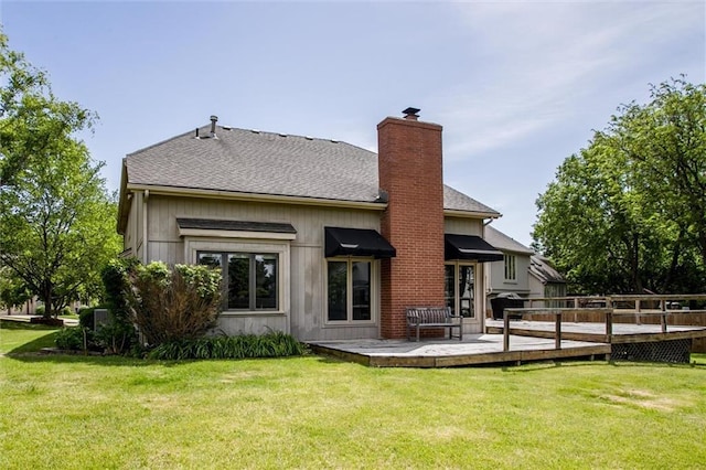 4837 W 121st St, Overland Park, KS 66209 - back of house with a chimney, a wooden deck, a lawn, and a shingled roof