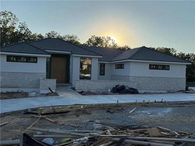 7410 NW Pampas Ln, Parkville, MO 64152 - view of front of house with stone siding, stucco siding, and a tiled roof