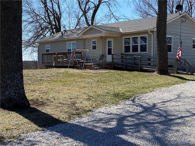 view of front of property with a shingled roof and a front yard