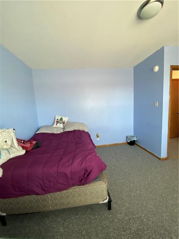 carpeted bedroom featuring baseboards and vaulted ceiling