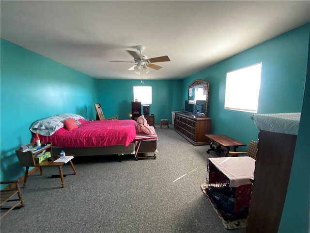 bedroom with multiple windows, a ceiling fan, and carpet floors