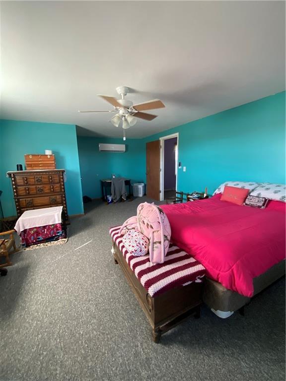 bedroom featuring a ceiling fan and a wall mounted AC