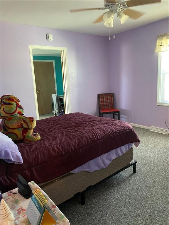 carpeted bedroom with baseboards and ceiling fan