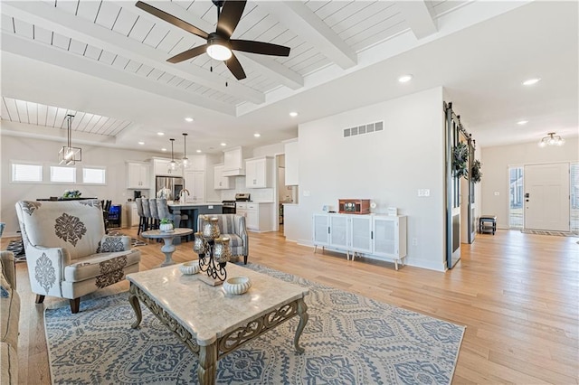 living room with visible vents, beam ceiling, recessed lighting, light wood-style floors, and baseboards