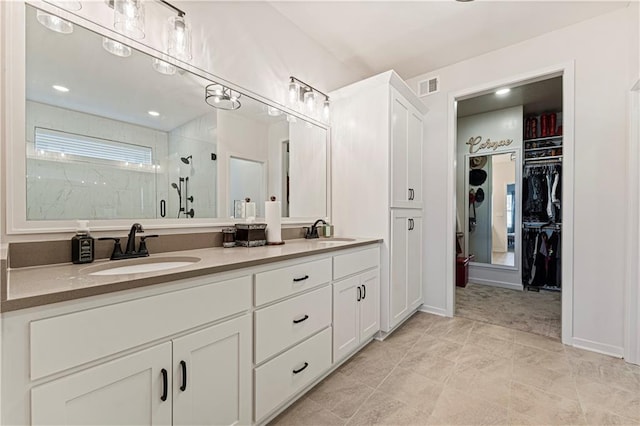 full bathroom with a sink, visible vents, a walk in closet, and a shower stall