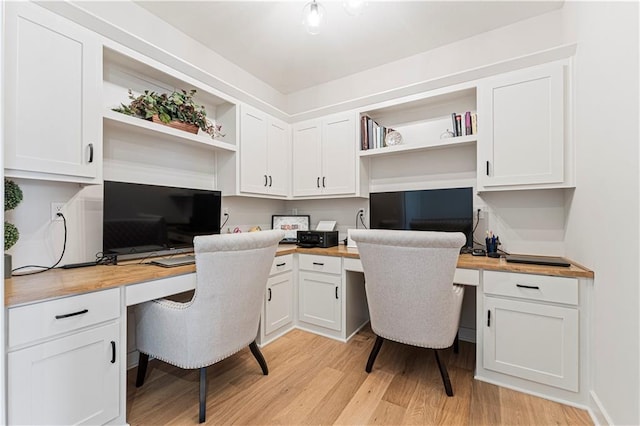 home office featuring light wood-type flooring and built in desk