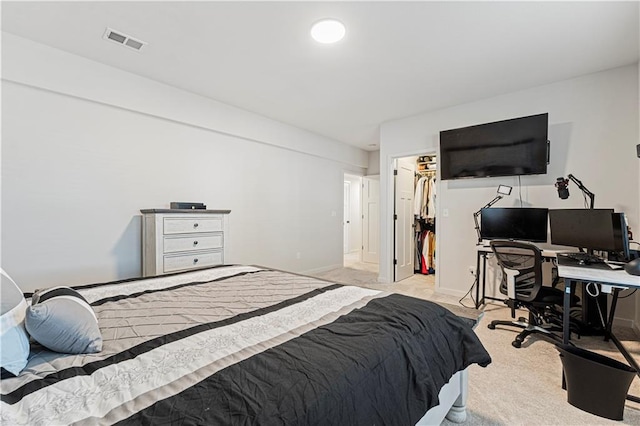 bedroom featuring visible vents, a walk in closet, baseboards, light colored carpet, and a closet