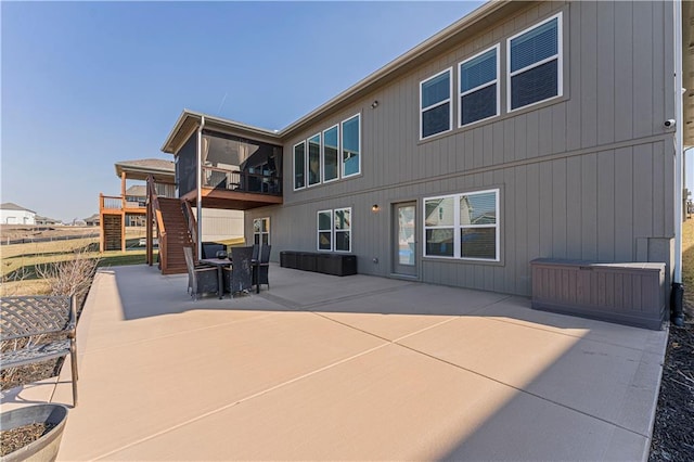 rear view of property with stairs, a patio, and a deck