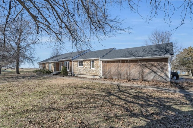 exterior space featuring stone siding and a front lawn