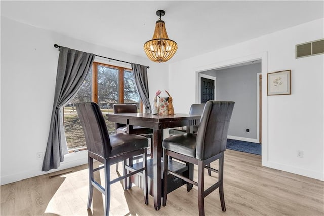 dining room featuring visible vents, a chandelier, and light wood finished floors