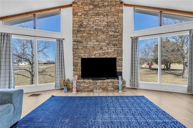 unfurnished living room with visible vents, high vaulted ceiling, and wood finished floors