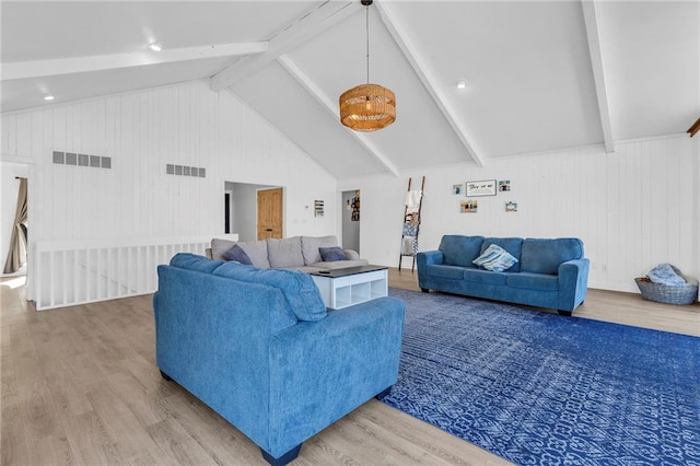 living area with vaulted ceiling with beams, wood finished floors, and visible vents