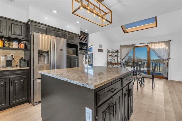 kitchen with open shelves, stainless steel fridge, and light wood-type flooring