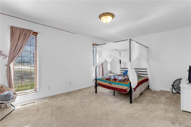 bedroom with visible vents, light colored carpet, and baseboards