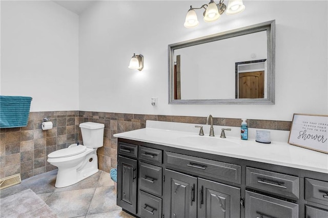 bathroom featuring a wainscoted wall, toilet, tile walls, and vanity