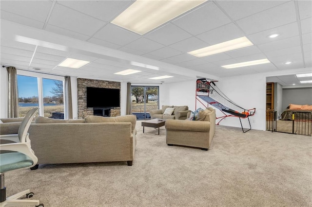 living area featuring light colored carpet and a drop ceiling