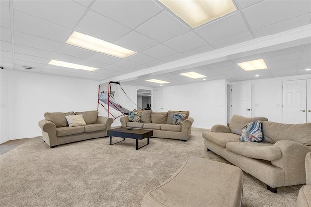 carpeted living area with a paneled ceiling