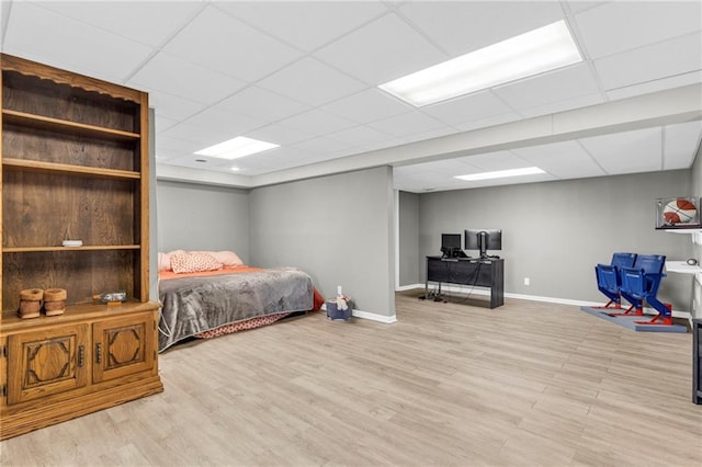 bedroom with wood finished floors, baseboards, and a drop ceiling