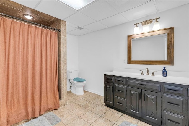 full bathroom with tile patterned floors, toilet, a drop ceiling, a shower with shower curtain, and vanity