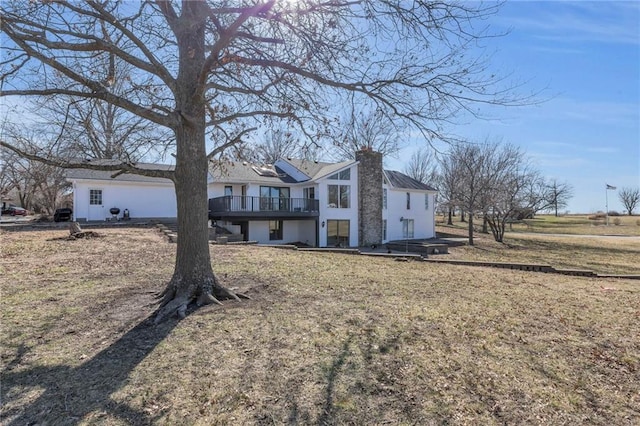 view of front of home with a deck, a front lawn, and a chimney