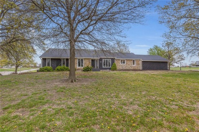 single story home featuring a sunroom and a front yard