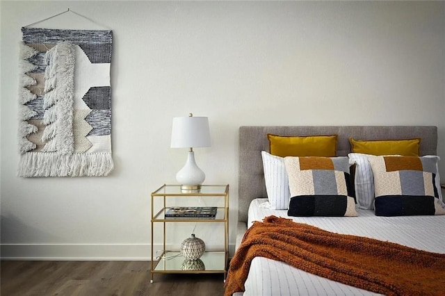 bedroom featuring baseboards and wood finished floors