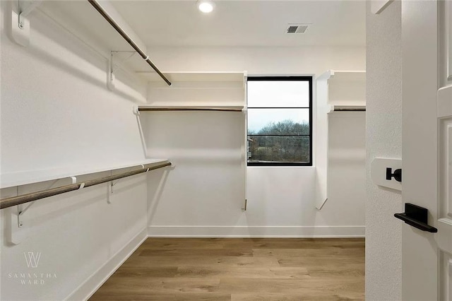 walk in closet with visible vents and wood finished floors