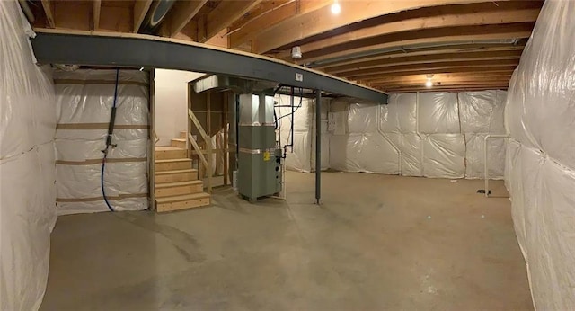 unfinished below grade area with heating unit and stairway