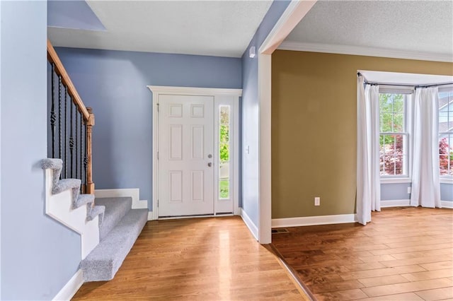 24987 W 150th Ct, Olathe, KS 66061 - foyer with stairs, a textured ceiling, baseboards, and wood finished floors