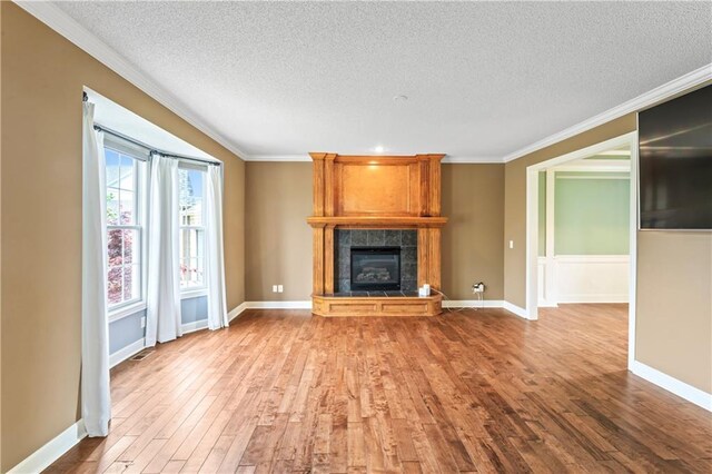 24987 W 150th Ct, Olathe, KS 66061 - unfurnished living room featuring a fireplace, crown molding, a textured ceiling, and wood finished floors