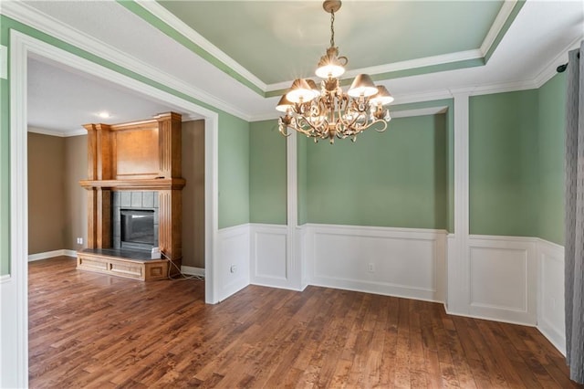 24987 W 150th Ct, Olathe, KS 66061 - unfurnished dining area with a notable chandelier, a wainscoted wall, wood finished floors, a raised ceiling, and a fireplace