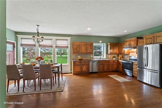 24987 W 150th Ct, Olathe, KS 66061 - kitchen featuring appliances with stainless steel finishes, a chandelier, brown cabinetry, dark wood finished floors, and recessed lighting