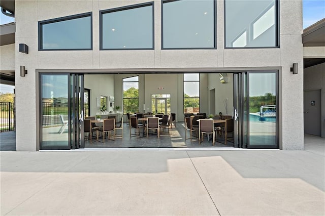 exterior space with stucco siding, outdoor dining area, and a patio