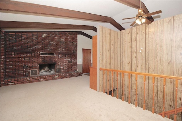 25237 NW Barton Rd, Westphalia, KS 66093 - unfurnished living room featuring ceiling fan, a brick fireplace, wood walls, carpet, and vaulted ceiling with beams