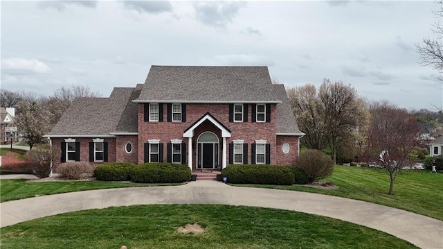 view of front of house featuring brick siding and a front lawn