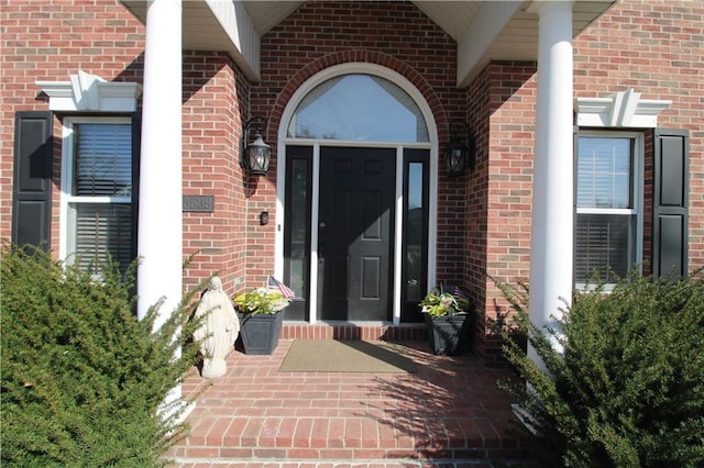 view of exterior entry with brick siding